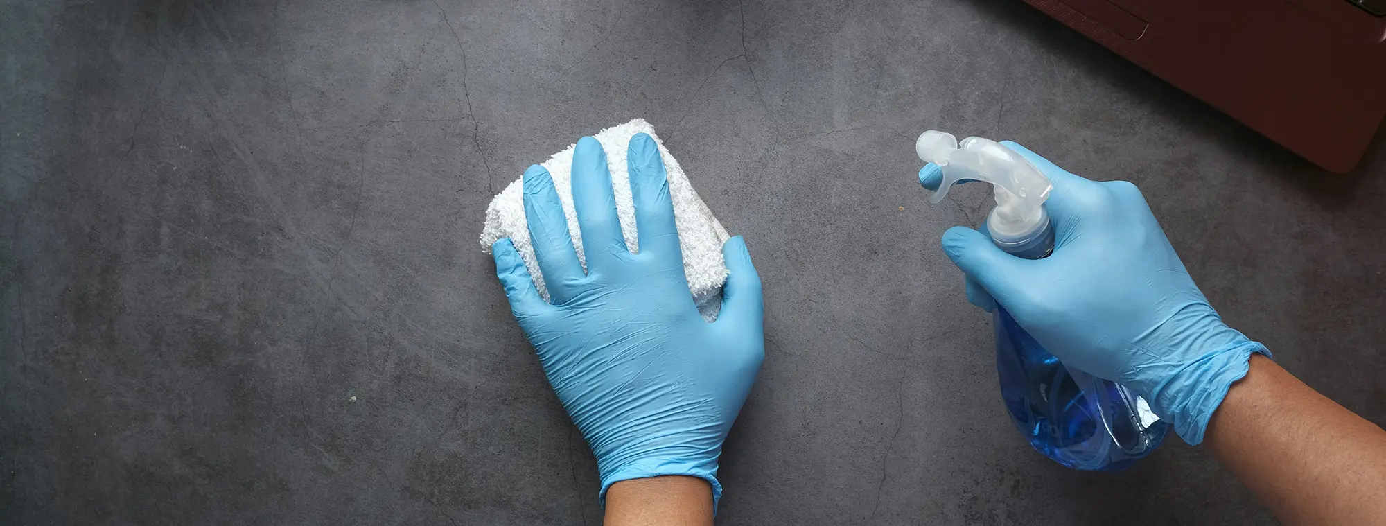 Image of a gloved hand cleaning surface.